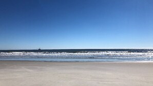 Ein Strand mit blauem Himmel und ruhiger See.