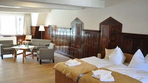 A hotel room with two beds, a sofa, a table, and a window with curtains. - Zentrum-Kloster-Lehnin (Kloster Lehnin)