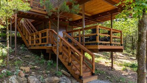 Una escalera de madera que conduce a una terraza con mobiliario exterior.