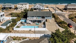 Um imóvel à beira-mar com piscina, várias casas e vista para o oceano.