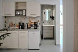 Eine moderne Küche mit Einbau-Mikrowelle, Kaffeemaschine und Kühlschrank.