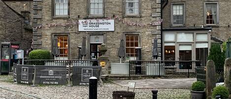 Un edificio de piedra con un letrero que indica 'Grassington House', señalando que es un restaurante y bar con habitaciones.