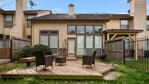 A two-story house with a deck, a satellite dish, and a fenced backyard. - Spacious Townhome With KING SUITE&Spa Tub (Houston)