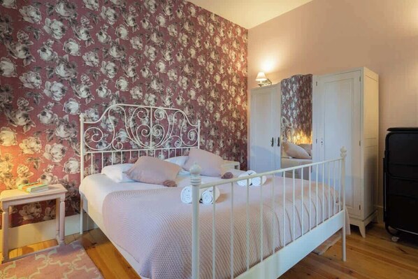 Une chambre à coucher avec un lit, une table de chevet, une armoire et un miroir.