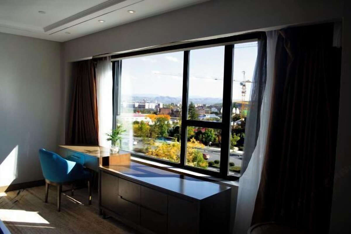 A modern room with a large window, a desk, and a chair.