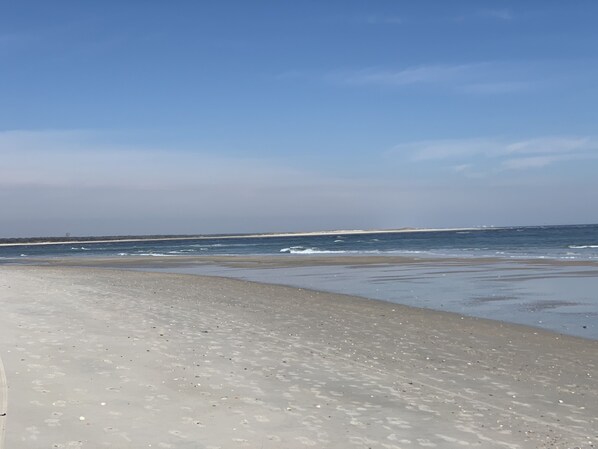 Une plage avec un ciel dégagé et une mer calme.