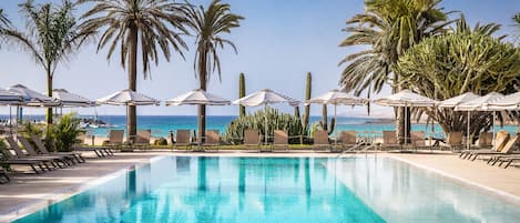 Piscine extérieure, parasols de plage, chaises longues