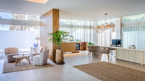 Un salon moderne avec un mur d’accent en bois, un coin repas et une cuisine dotée d’une grande fenêtre.