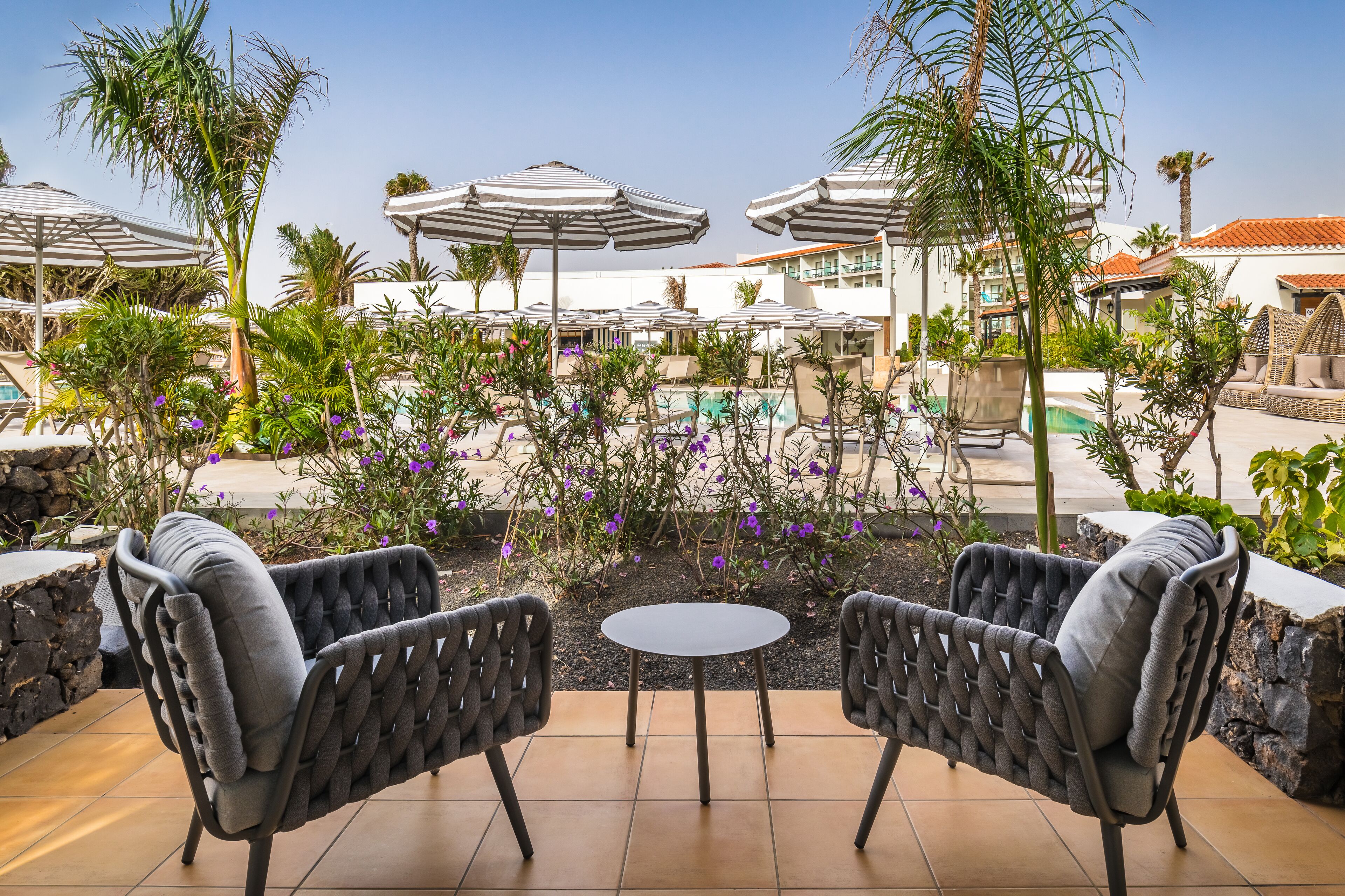 A poolside area with outdoor seating and umbrellas.