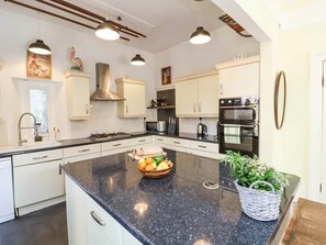 A modern kitchen with white cabinets, a granite countertop, and stainless steel appliances.