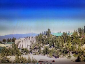 A hotel with multiple floors, surrounded by dense forest and a mountain in the background. - Experience Tahoe's Ski Scene at Holiday Inn Club Vacations Tahoe Ridge Resort (Stateline)