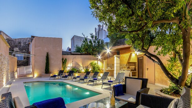 A poolside area with lounge chairs, a glass table, and a bottle. - Town55, House 5StarsHome Mallorca (Pollensa / Pollença)