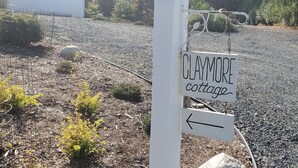 A sign for Claymore Cottage with an arrow pointing left. - A modern cozy cottage in your own wooded backyard located mid Vancouver Island. (Qualicum Beach)