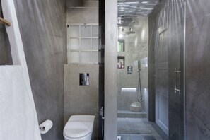 A modern bathroom with a toilet, shower, and glass-enclosed vanity. - Stylish, Quiet & Relaxing, a Hidden Gem near the Acropolis (Athina)