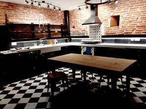 Een keuken met een geruite vloer, een houten tafel en een hanglamp.