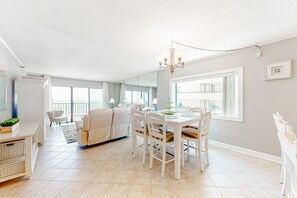 Cozy living area with a dining table for four, surrounded by comfortable chairs and a large window.