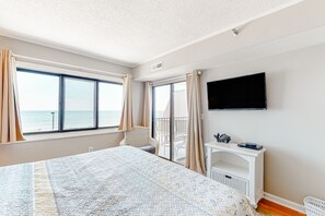 Enjoy a restful stay in this inviting room with a large bed, TV, and console table, offering a beautiful sea view.