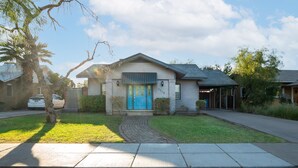A residential house with a blue front door, a brick pathway leading to the entrance, and a well-maintained lawn. - Home in the Historic Coronado District 2bed,1 bath (Phoenix)