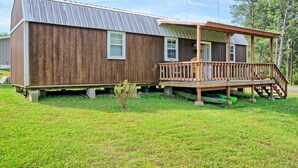A wooden cabin with a porch and a small deck.