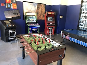 Ein Raum mit einem Kicker, zwei Spielautomaten und einem Kicker mit dem Schild 'Power Hockey'.