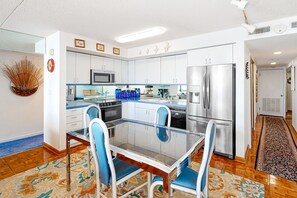 Enjoy meals at the glass dining table surrounded by comfortable chairs.