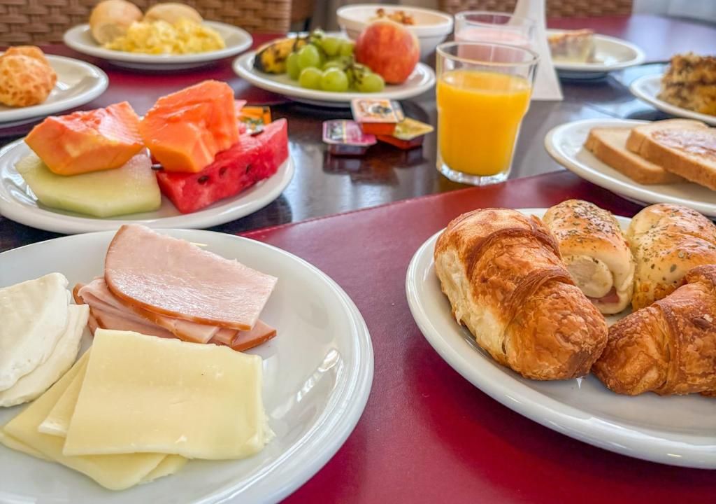Een ontbijtbuffet met diverse gerechten en een glas sinaasappelsap.