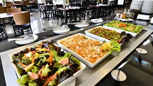 Un bufé con ensaladas y platos variados.