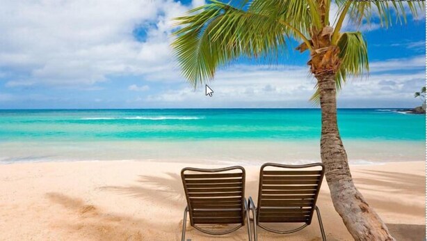 En strandscene med to tomme stole under en palme, med udsigt over et turkisblåt hav.