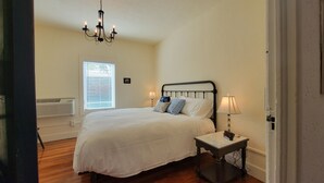 Ein Schlafzimmer mit Bett, Nachttisch, Lampe und einer Chandelier.