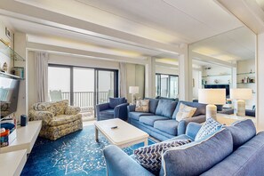 Relax in this spacious living room with a sofa set, coffee table, and large window offering a view of the outside.