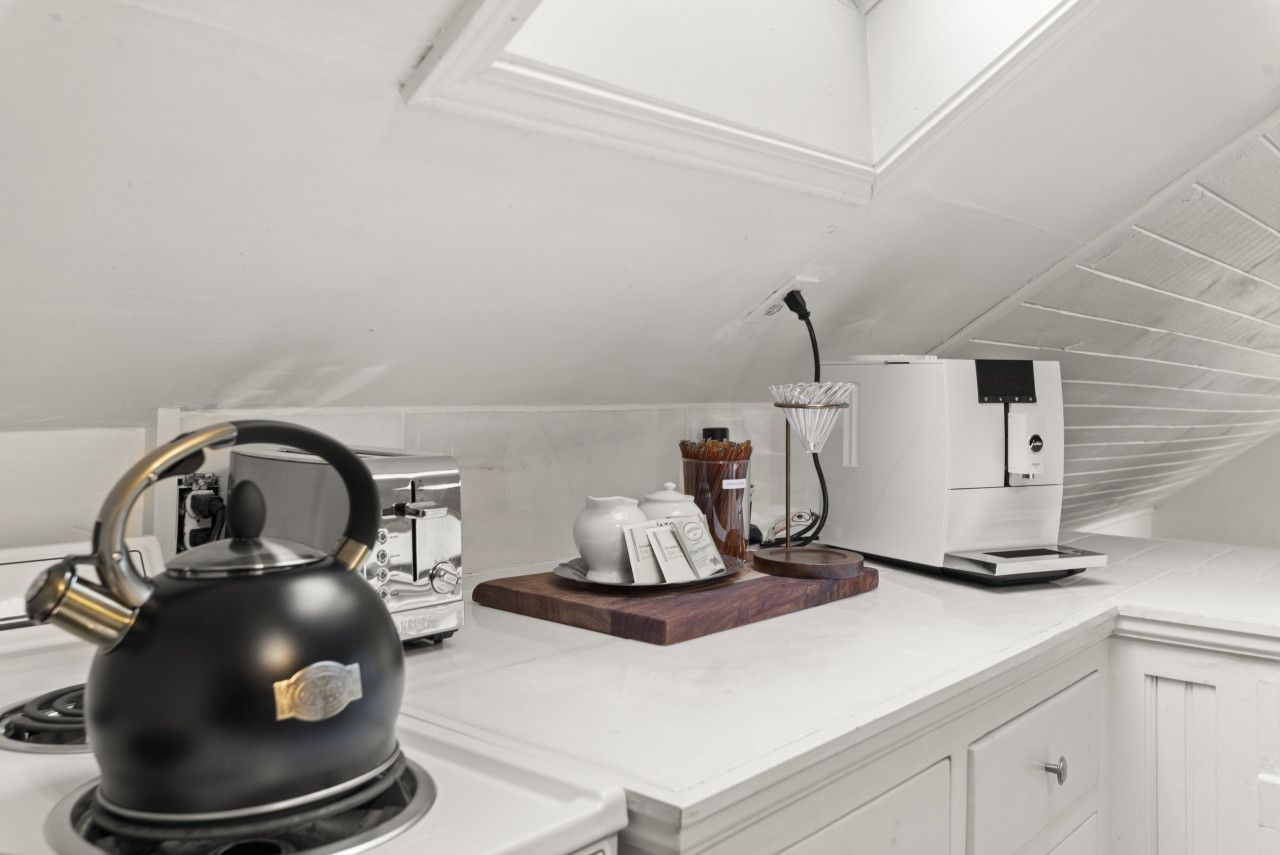 A modern kitchen with a kettle, a coffee maker, and a toaster on the countertop.