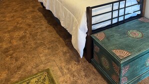 Een slaapkamer met een bed, een houten garderobe en een groene dressoir.