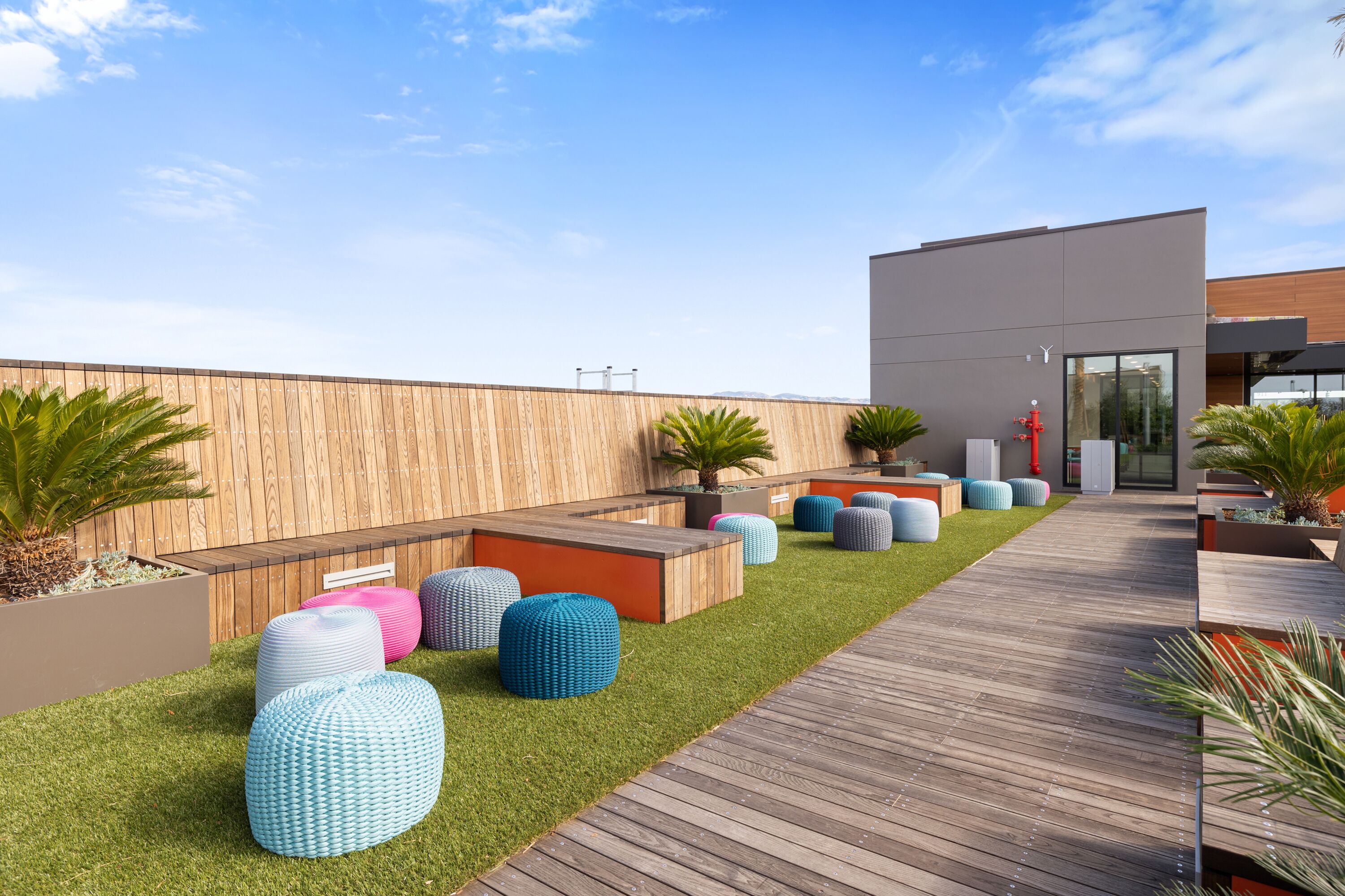 A modern outdoor seating area with colorful, textured seating and a wooden deck.