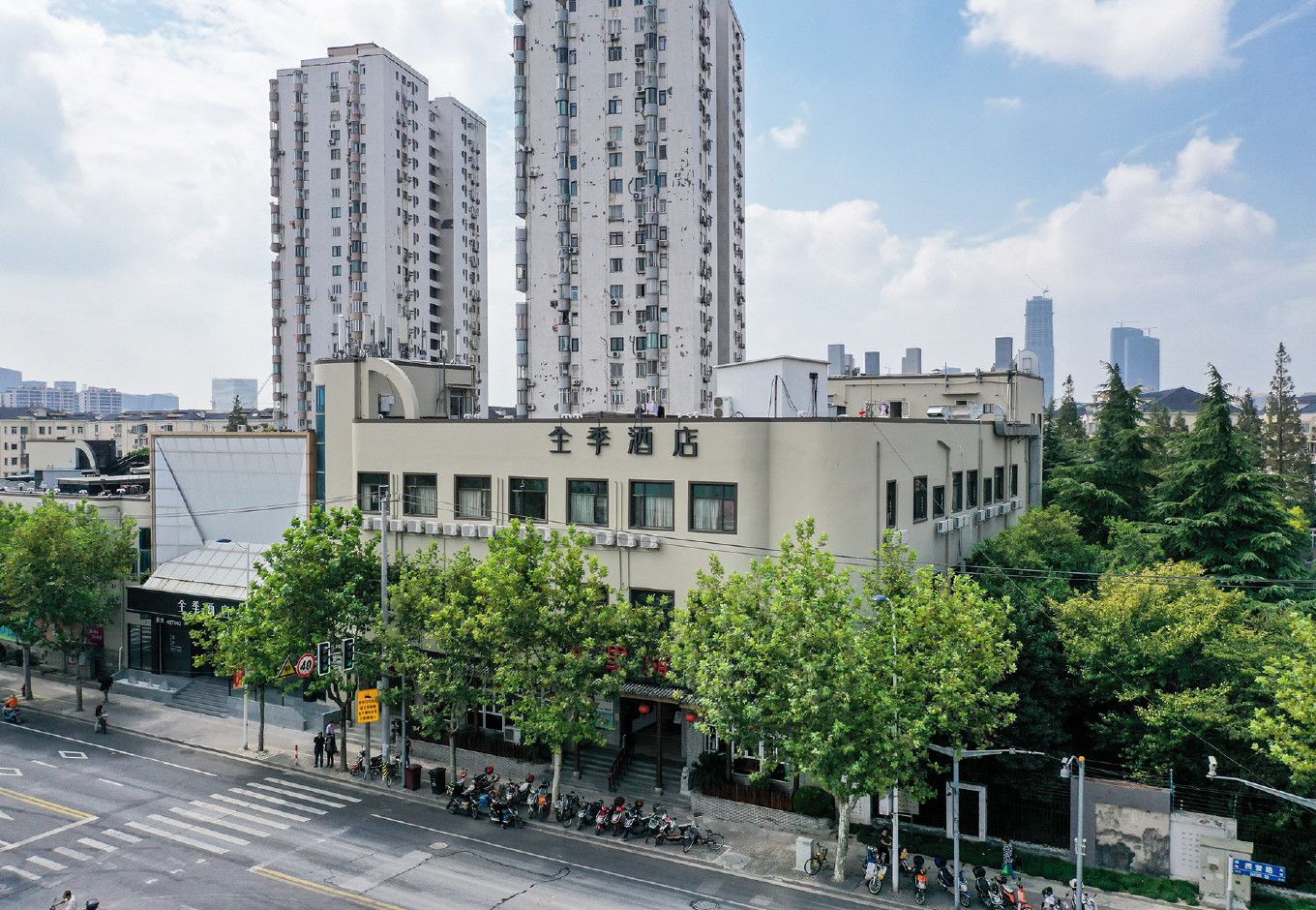 A building with multiple floors, a sign with Chinese characters, and a street with parked motorcycles.