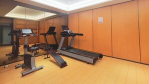 A gym with treadmills, a stationary bike, and a rowing machine.