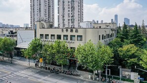 A building with multiple floors, a sign with Chinese characters, and a street with parked motorcycles.