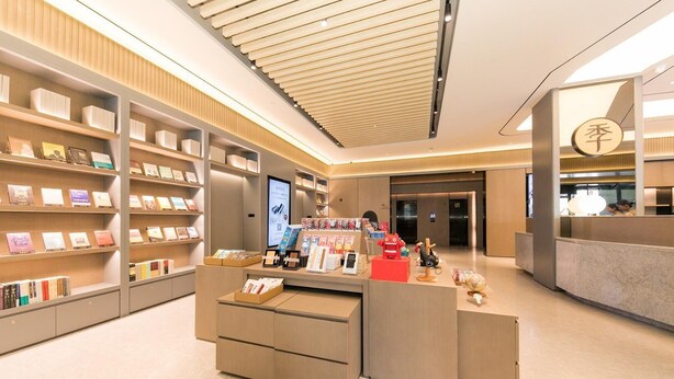 A bookstore interior with shelves, a checkout counter, and a digital display.