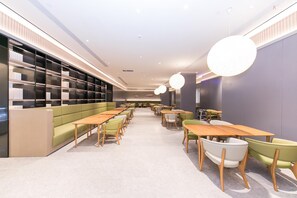 A modern library with bookshelves, seating areas, and tables.