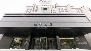A hotel entrance with a modern design, featuring a revolving door and a clear sign indicating the hotel's name. - Ji Hotel Wuxi Railway Station Branch (Wuxi)