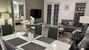 En moderne stue med spiseområde, sofa og fjernsyn.