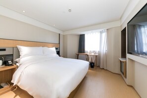A hotel room with a large bed, bedside table, and a TV. - Ji Hotel (Shanghai)