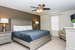 A bedroom with a bed, nightstands, a ceiling fan, a dresser, and a window with curtains. - Modern 5BR/5BA Vacation Home with Private Pool CG1593 (Davenport)