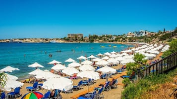 En la playa, sillas reclinables de playa, toallas de playa