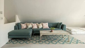 A modern living room with a sectional sofa, a coffee table, and a patterned rug.