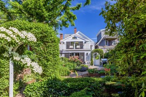 Classic home with a lush garden and patio area, perfect for relaxation and socializing.