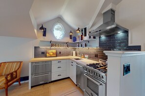 Enjoy cooking in this well-equipped kitchen with a stainless steel range hood, oven, and gas stove.