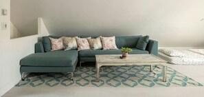 A modern living room with a sectional sofa, a coffee table, and a patterned rug.