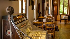 Un jukebox antiguo en una habitación acogedora con muebles de madera y un ventanal grande.