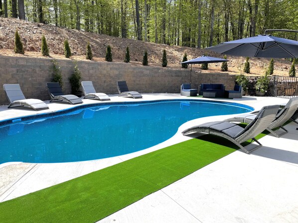 Ein Schwimmbad mit Liegestühlen und einer Terrassenanlage.