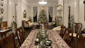 A dining room with a Christmas tree, a chandelier, and a fireplace. - Belle Louise Historic Guest House (Paducah)